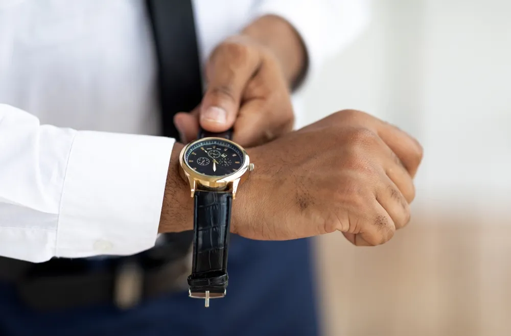 Closeup of businessman wearing expensive wrist watch with leather strap band